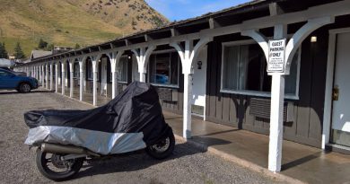 Covered motorcycle parked in front of motel.